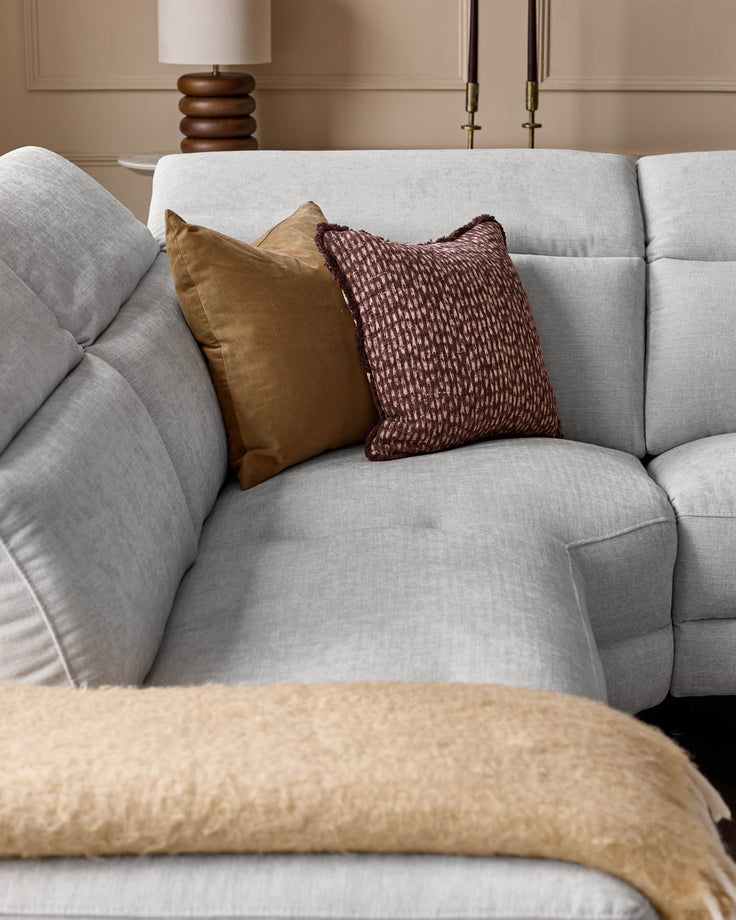 Light grey upholstered left-corner recliner sofa with decorative gold and burgundy patterned pillows, angled view.