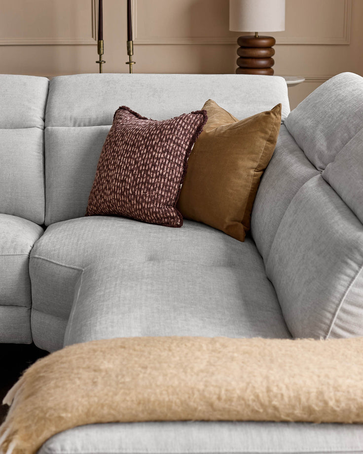Light grey fabric right-hand corner recliner sofa with burgundy and mustard decorative pillows, styled in a modern living room setting.