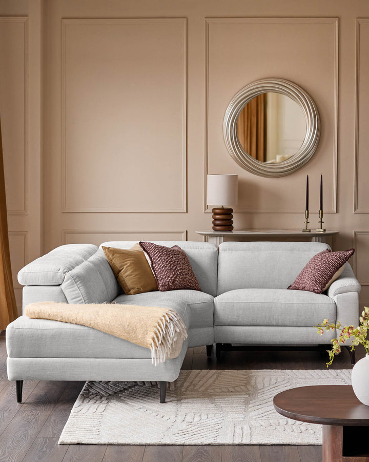 Light grey fabric left-corner recliner sofa with rolled arms and dark legs, styled in a neutral living room setting.