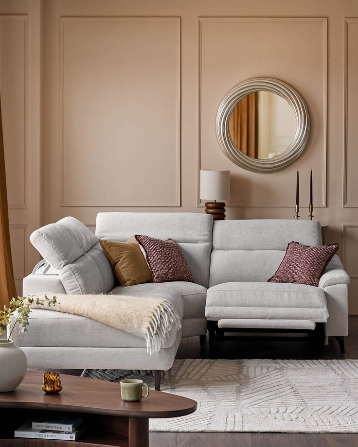 Serene left small corner recliner sofa in light grey fabric, displayed in a neutral living room setting with cushions and throws.