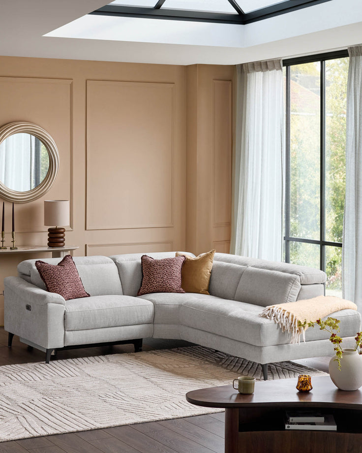 Light grey fabric right-hand corner recliner sofa in a modern living room with neutral decor and skylights.