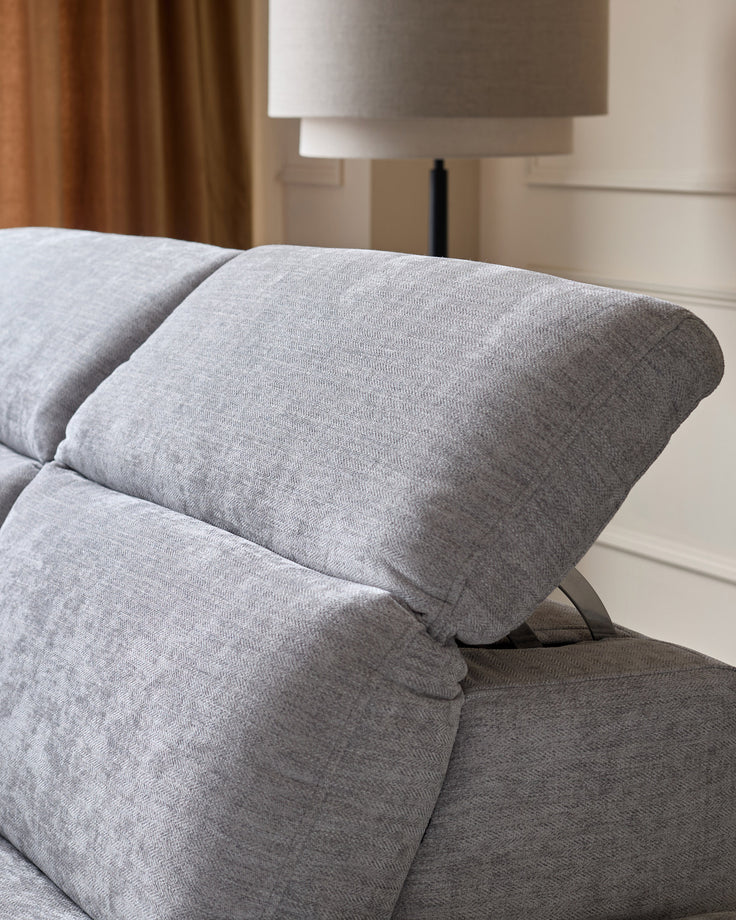 Grey chenille left chaise recliner sofa with rolled armrest and angled metal legs, shown in bedroom setting.