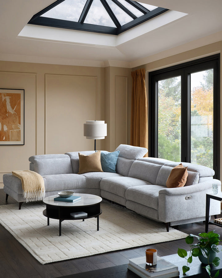 Serene left chaise recliner sofa in light grey chenille, displayed in a modern living room with skylight and black-framed doors.