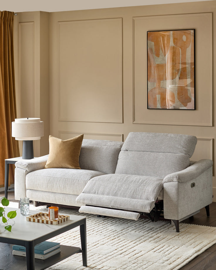Serene 3-seater light grey fabric recliner sofa with extended footrests in a modern living room setting.