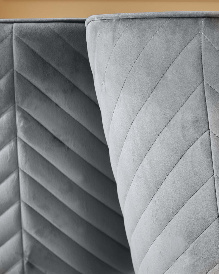 Close-up of quilted grey velvet furniture, showcasing its texture and design.