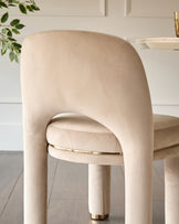 Shay dining chair in champagne velvet, shown from back view with curved backrest and gold leg detail.
