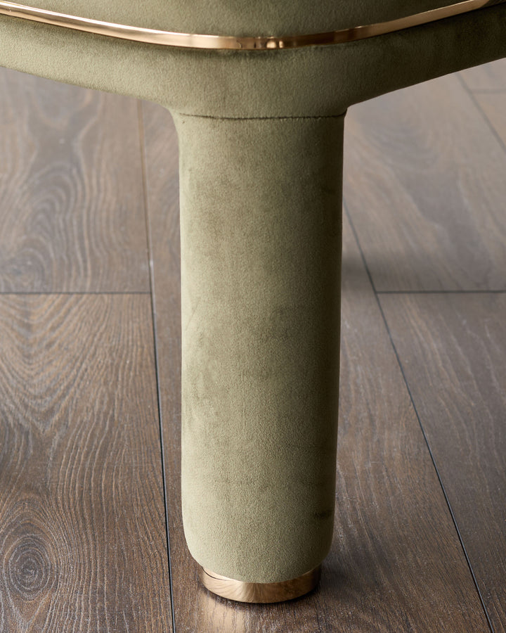 Shay Dining Chair in Olive Green Velvet - Close-up of cylindrical base with brass metal detail on wood flooring.