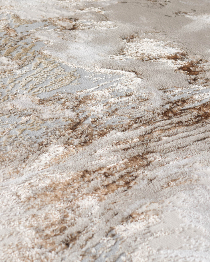 Close-up of a textured, modern rug with a beige and grey abstract pattern. Soft, textured pile detail visible.