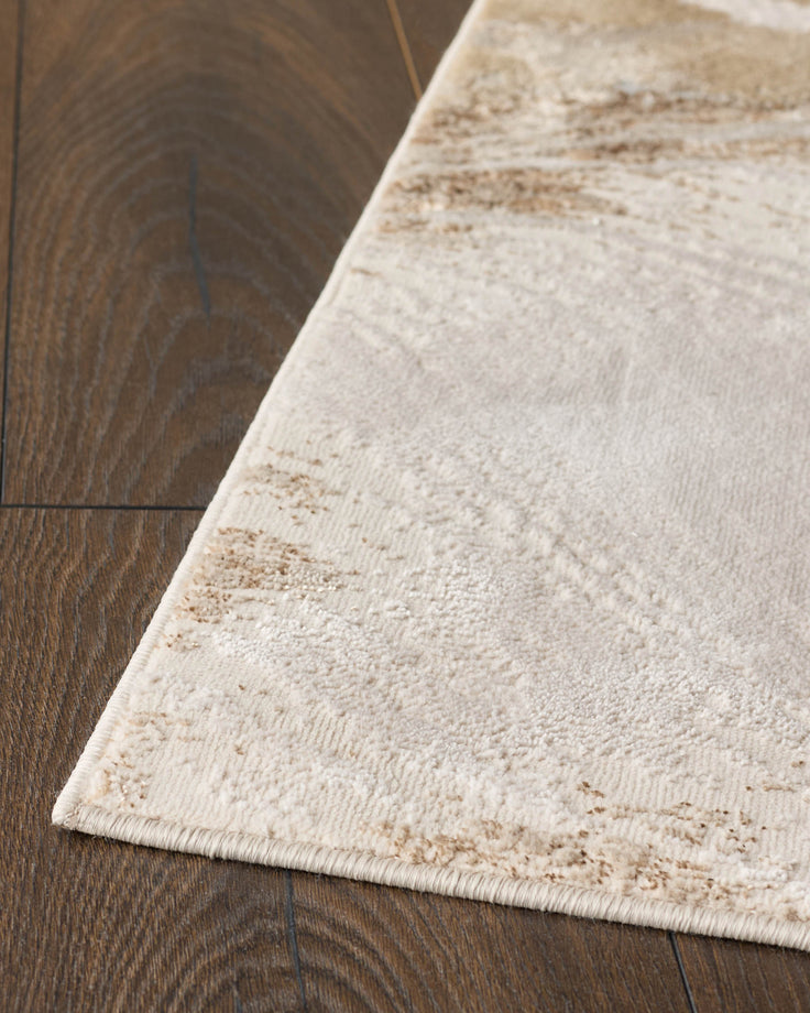 A patterned, cream rug lies on a dark wood floor, creating a warm and inviting contrast.