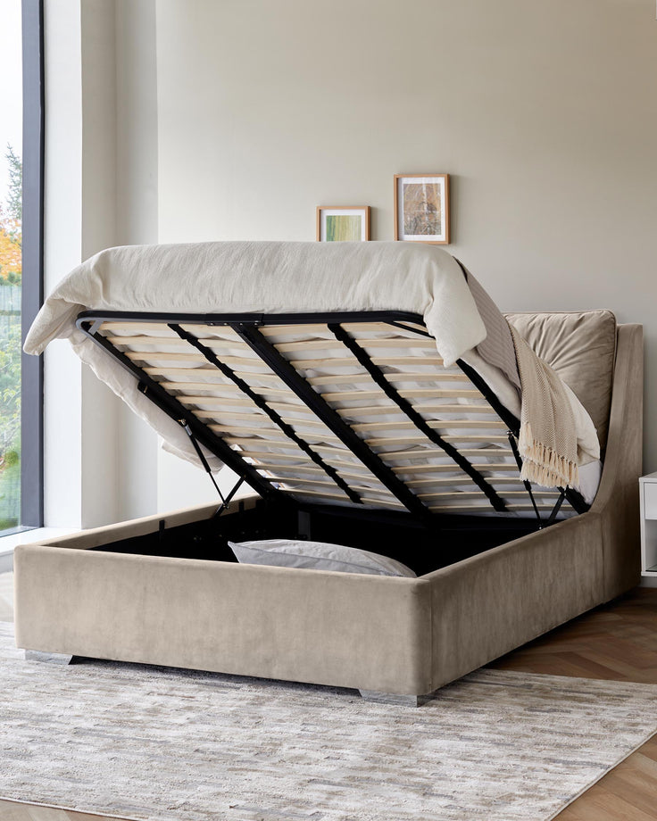 An open, beige, ottoman bed shows its storage space with a stylish rug, and modern design for space-saving and elegance.