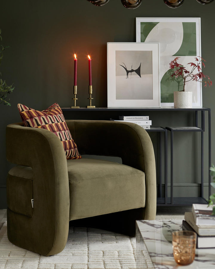Stylish olive armchair with patterned cushion, complemented by framed prints and elegant candle holders on a console table.