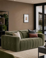 Skye 2-seater sofa in dark green fabric with vertical quilted channels, displayed in a modern living room setting.