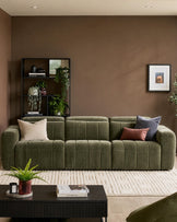 Skye 3-seater sofa in dark green fabric with quilted channel detailing and rounded arms, styled in a warm taupe living room.