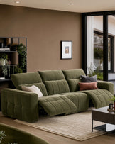 Skye 3-seater sofa in dark green fabric with quilted detailing and curved armrests, displayed in a warm-toned living room setting.