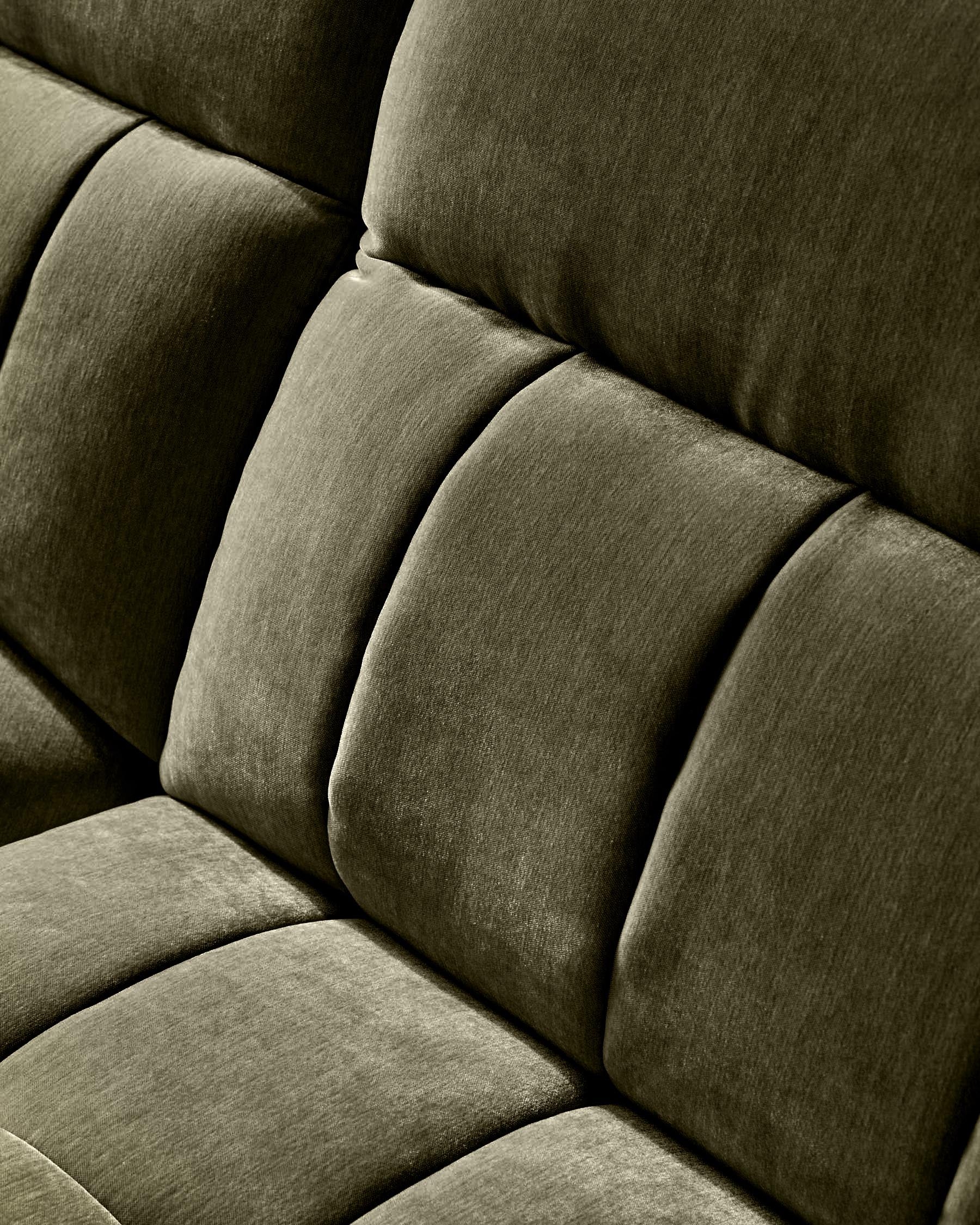 Close-up of dark green fabric sofa showing quilted cushioned backrest and seat detail.