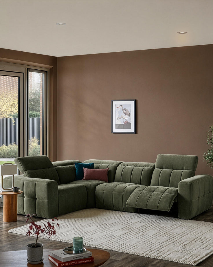 Skye small corner sofa in dark green fabric with quilted seat cushions, positioned in a modern living room with warm brown walls.