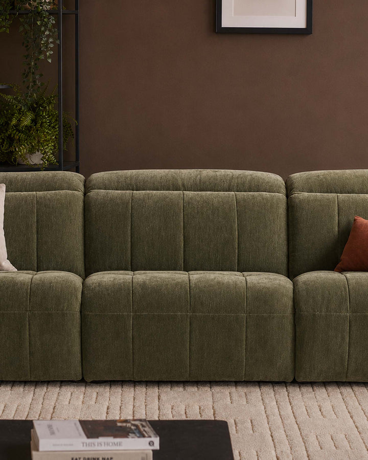 Skye single sofa module in dark green fabric with quilted channel detailing, shown as part of a modular sectional arrangement.