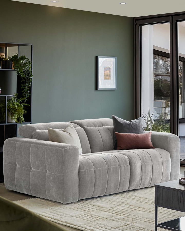 A stylish grey sofa with throw cushions sits in a well-lit room, showcasing modern design and comfort.