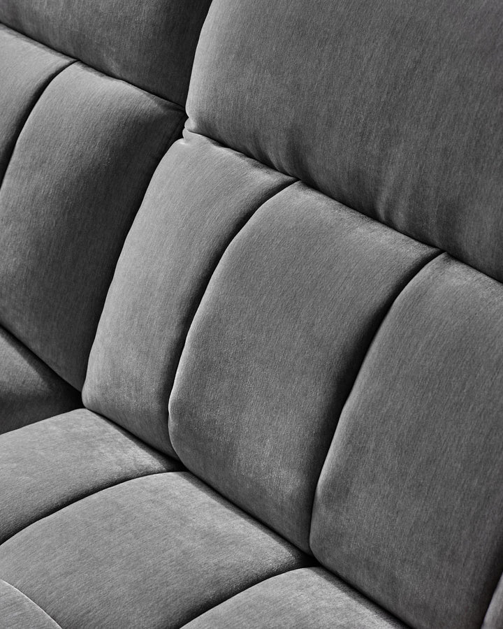 Close-up of a plush, gray upholstered sofa with a modern design, featuring thick, soft cushions for comfort and style.
