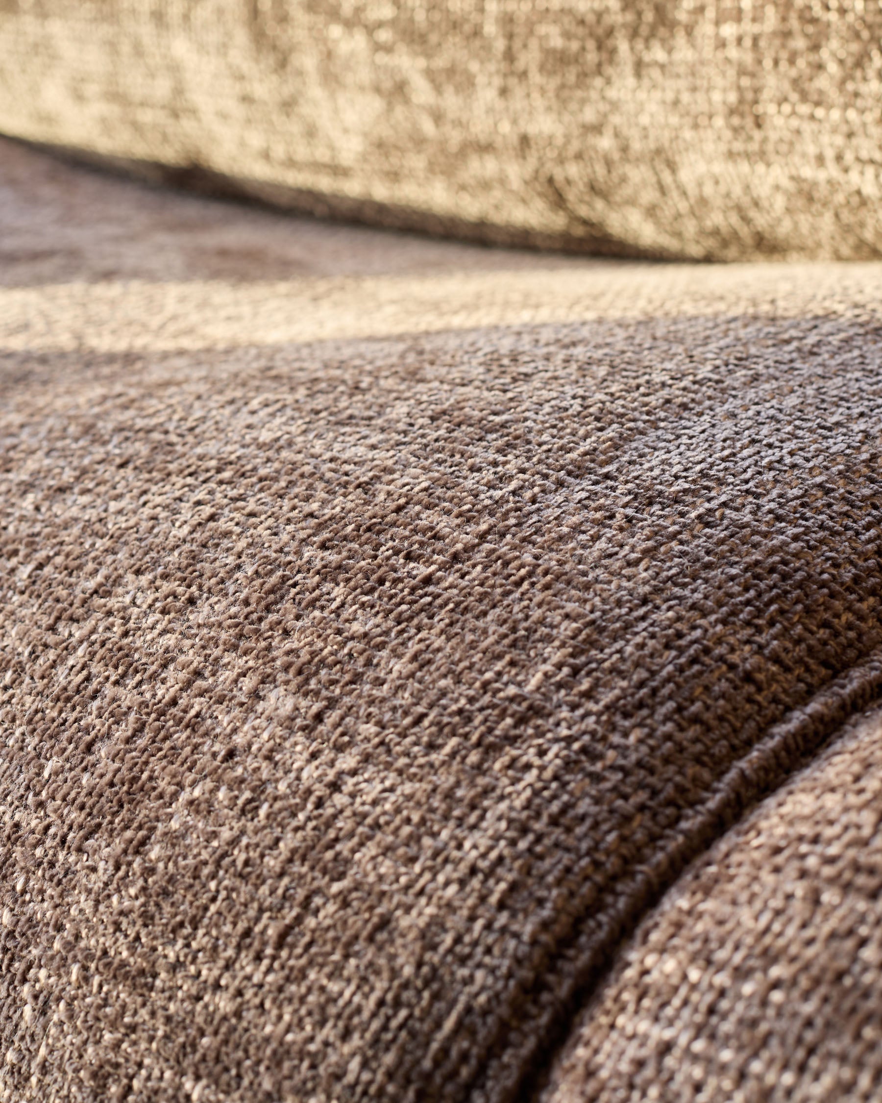 Close-up of mocha fabric texture on Sofia accent chair, showing woven material detail against white wall.