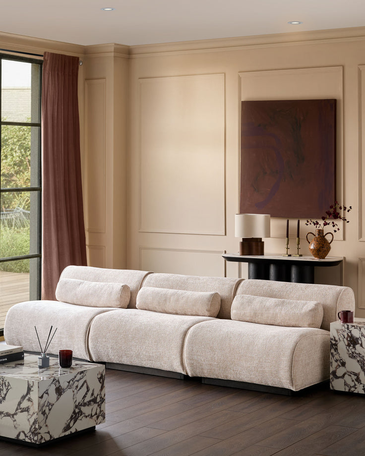 Sofia 3-seater sofa in natural fabric with curved barrel-back design and black base, styled in modern living room.