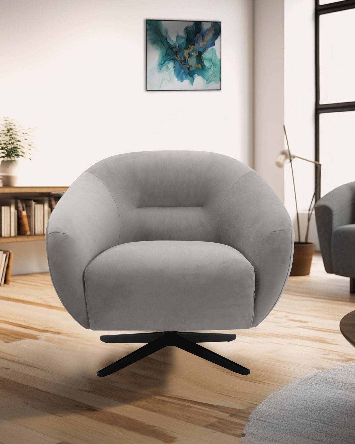 Modern grey swivel armchair with a plush, rounded design, and a sleek, black, star-shaped base, displayed in a contemporary living room setting with natural light.