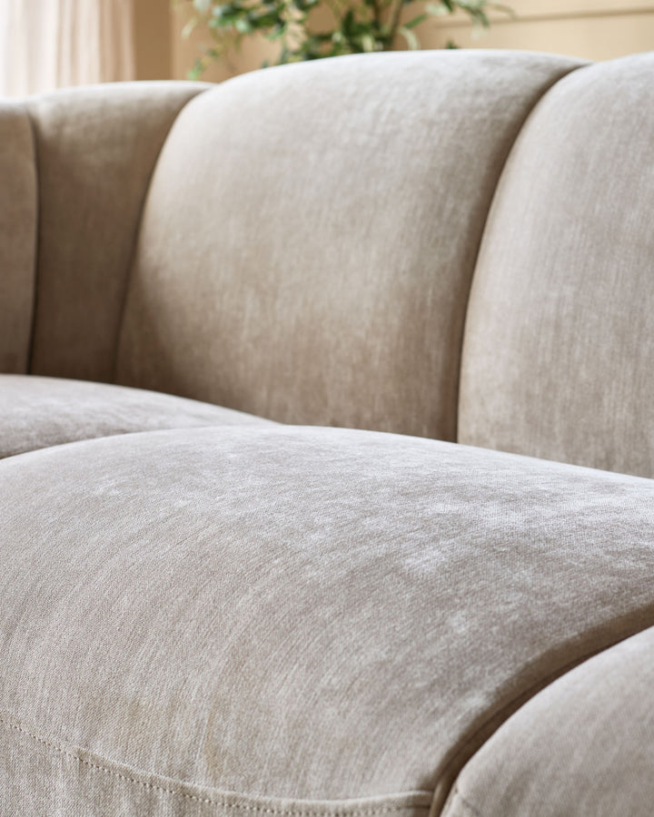 Teagan 3-seater sofa in champagne fabric, close-up detail showing soft upholstery and curved armrests.