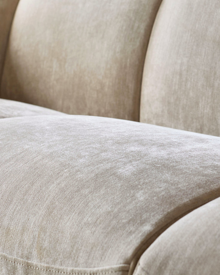 Teagan 2-seater sofa in champagne fabric, close-up of seat and backrest cushions showing texture and neutral tone.