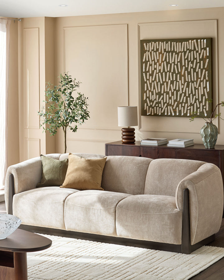Teagan 3-seater sofa in champagne fabric with curved arms and dark wood base, styled in a neutral living room.
