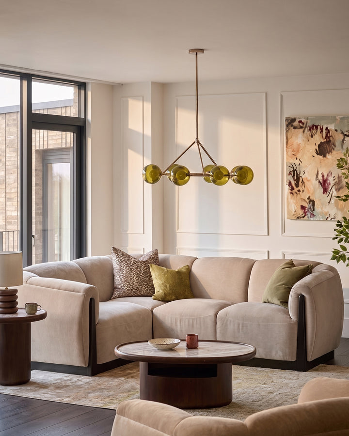 Teagan left-hand small corner sofa in champagne fabric, shown in a styled living room setting with coordinating cushions and pendant lighting.