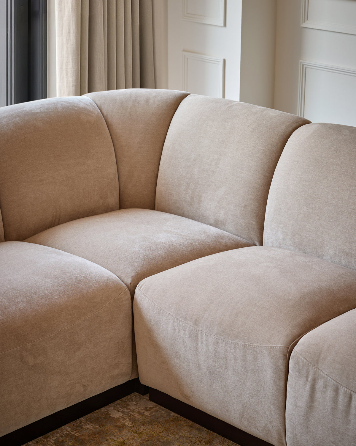 Teagan left-hand small corner sofa in champagne fabric, showing curved modular design with rounded armrests and piped seams.