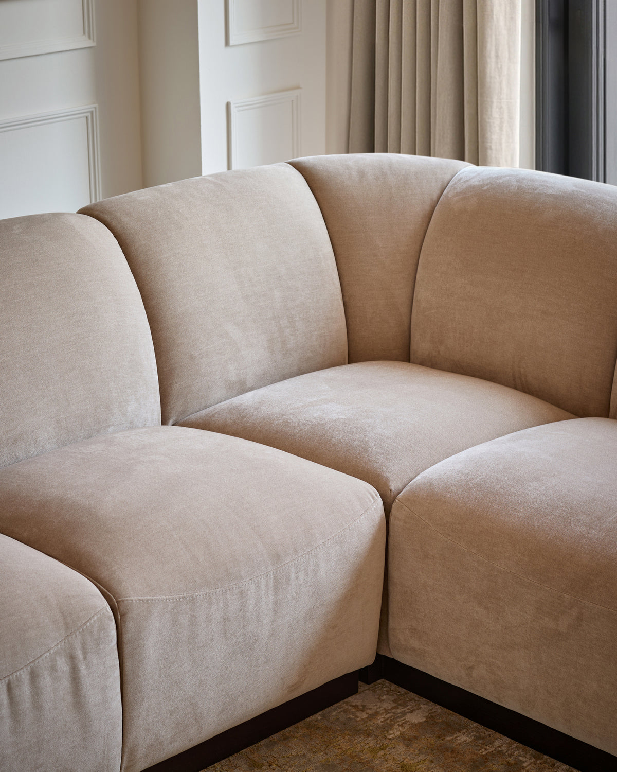 Teagan right-hand small corner sofa in champagne fabric, close-up of curved seating sections in a neutral room setting.