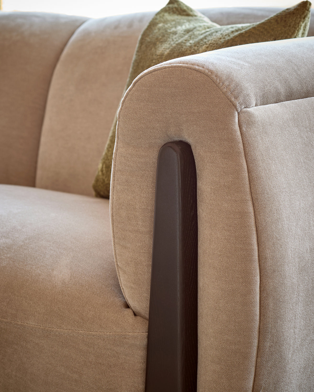 Teagan right-hand corner sofa in champagne fabric with dark wood armrest detail, close-up view.
