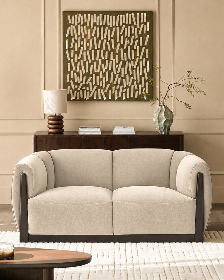 Teagan 2-seater sofa in champagne fabric with dark wood frame and curved armrests, displayed in a styled living room.