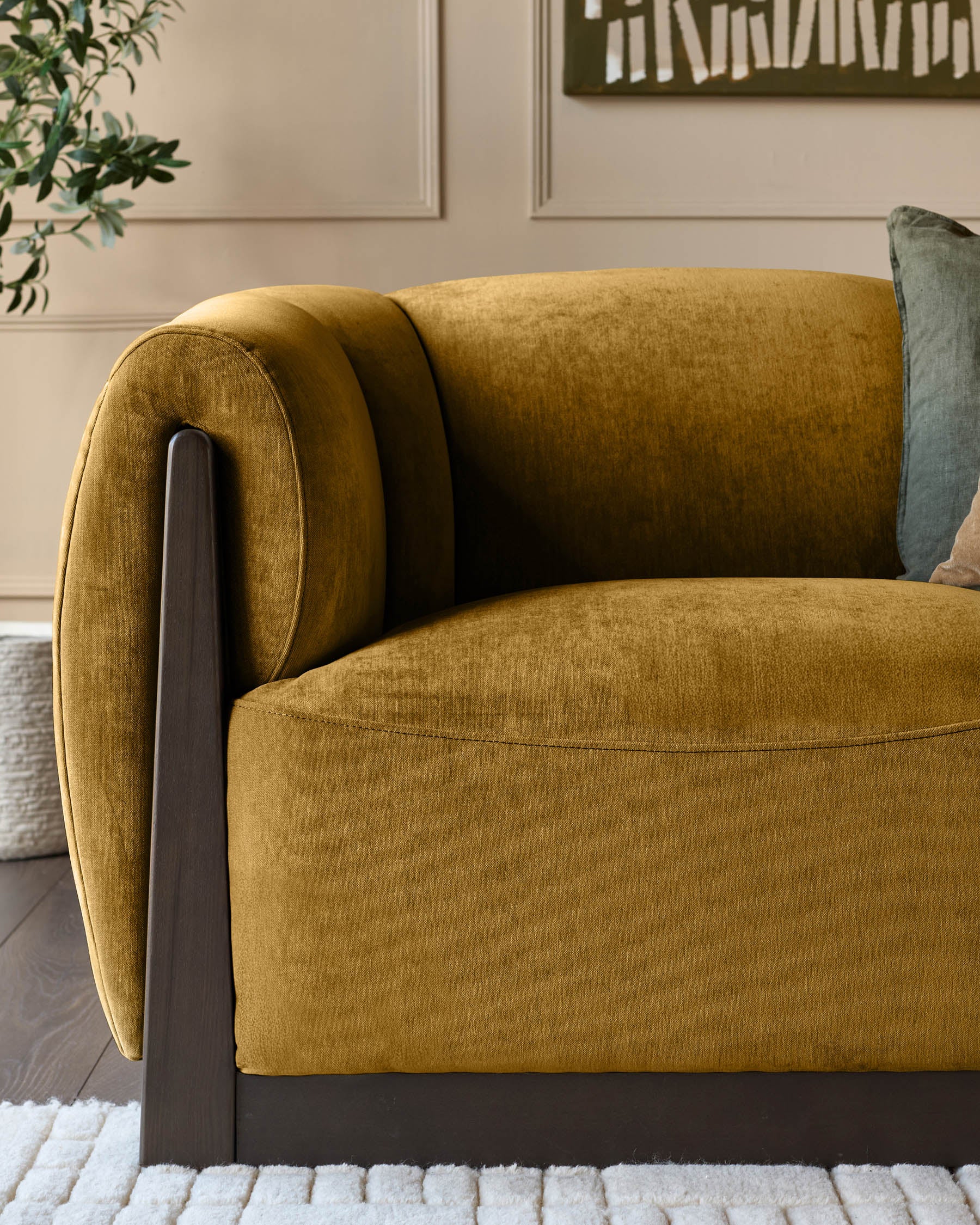 Teagan 2-seater sofa in ochre fabric with dark wood frame and rolled armrests, side angle view.