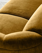 Teagan 2-seater sofa in ochre fabric, close-up detail showing curved armrest and plush upholstery texture.