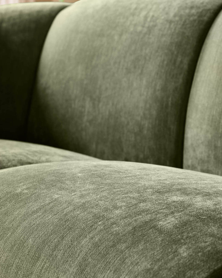 Teagan 2-seater sofa in olive green fabric, close-up detail of cushioned seat and curved armrests.