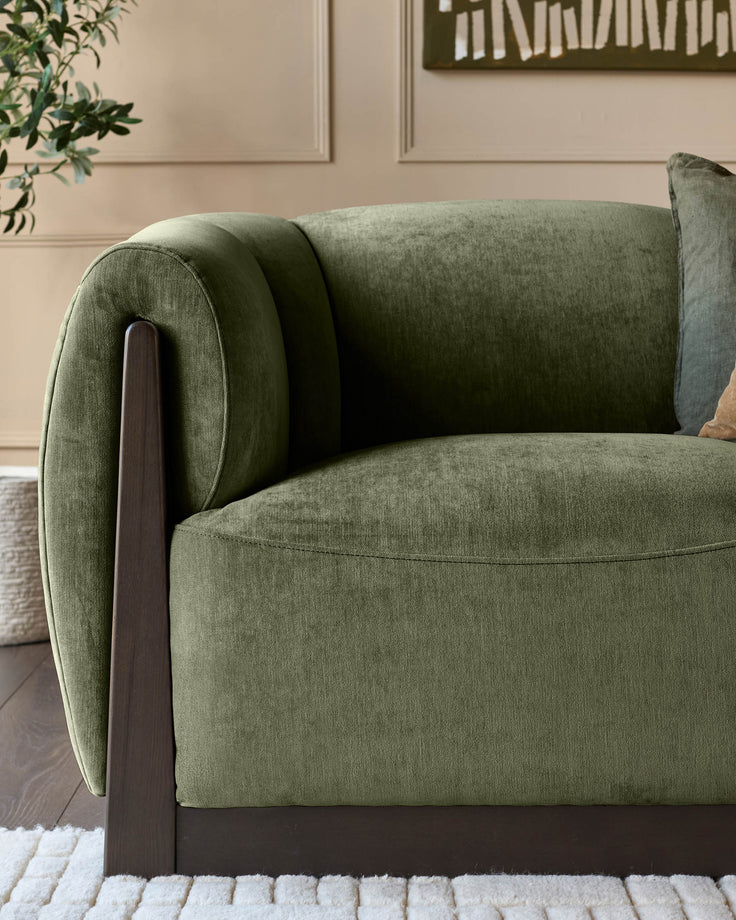 Teagan 2-seater sofa in olive green fabric with rolled arms and dark wooden legs, shown from a side angle.