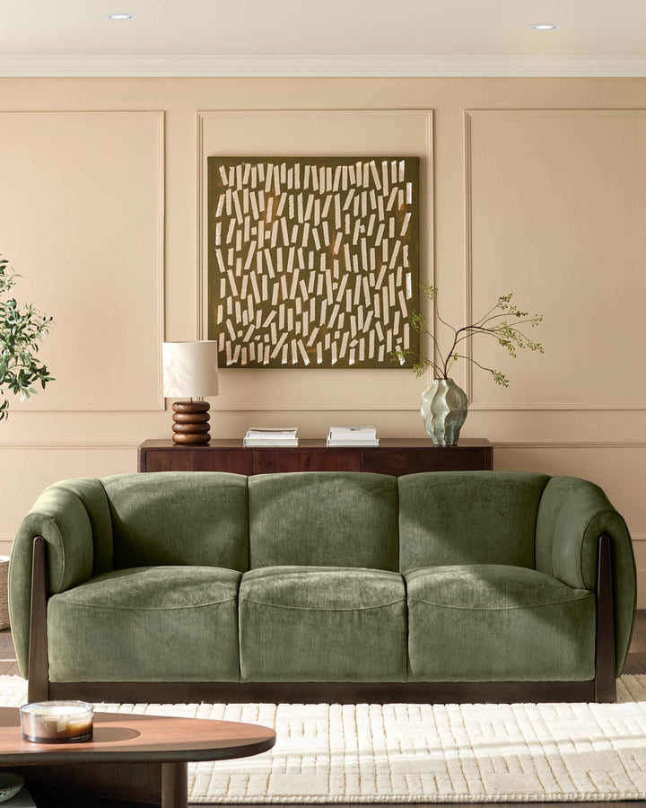 Teagan 3-seater sofa in olive green fabric with curved arms and dark wood frame, styled in a modern living room.