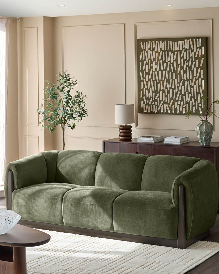 Teagan 3-seater sofa in olive green fabric with curved arms and dark wood base, styled in a living room setting.