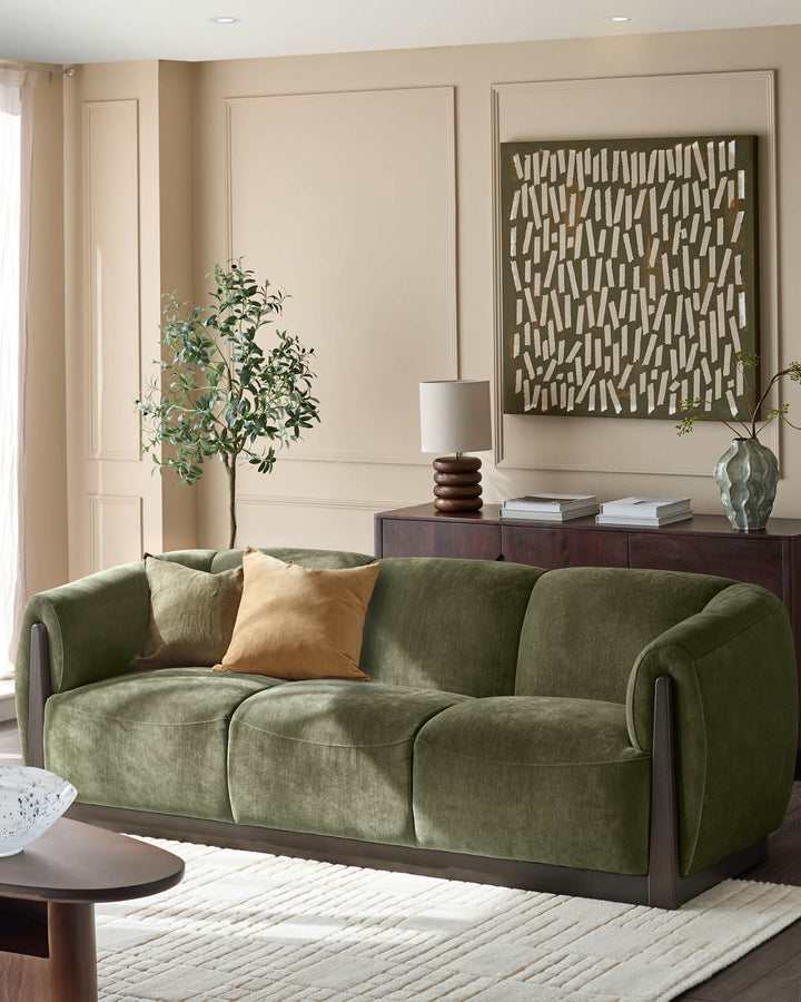 Teagan 3-seater sofa in olive green fabric with curved arms and dark wood base, styled in a neutral living room.