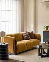 Teagan 3-seater sofa in ochre fabric with black base, styled in a modern living room setting.