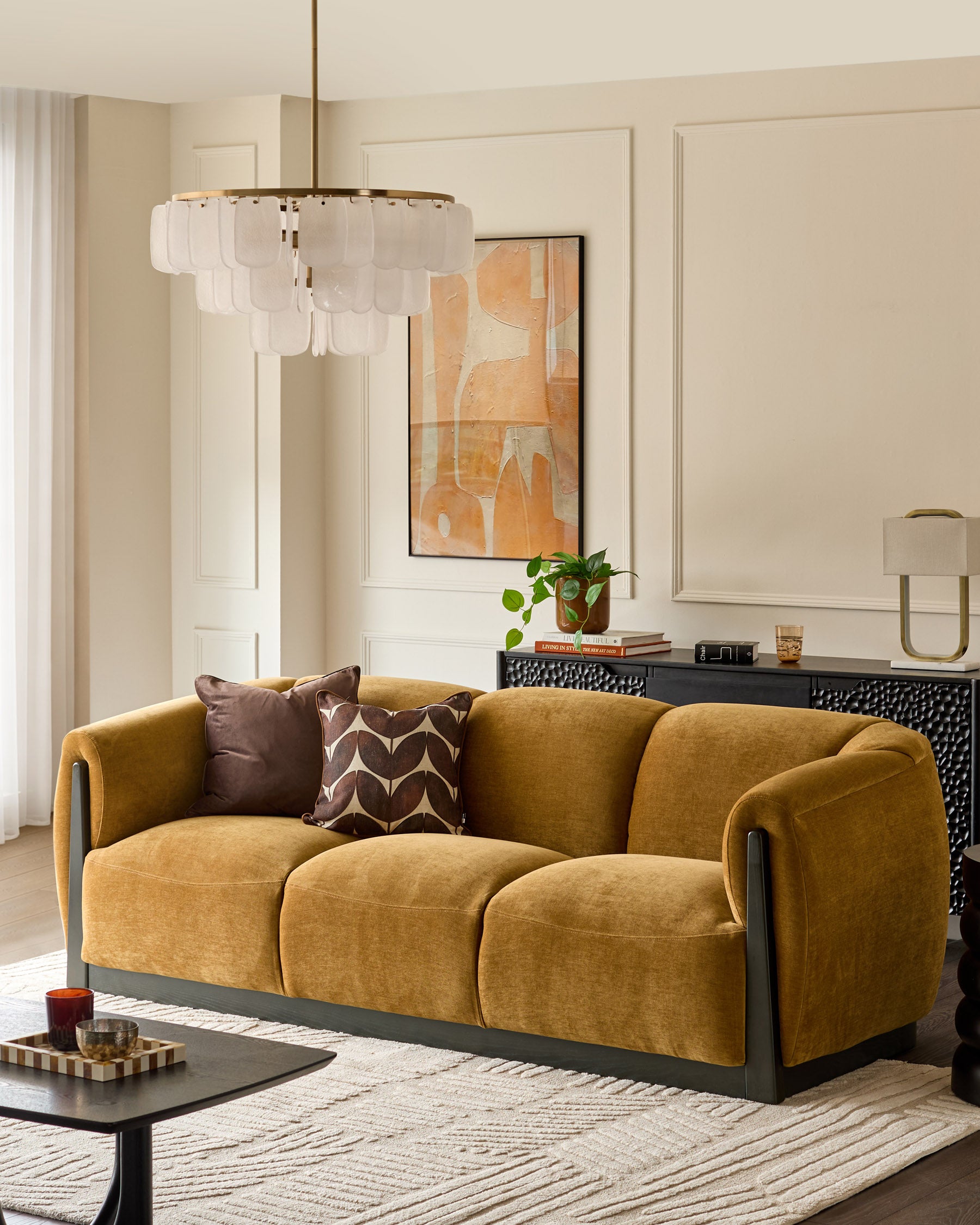 Teagan 3-seater sofa in ochre fabric with black wooden base and curved armrests, styled in a modern living room.