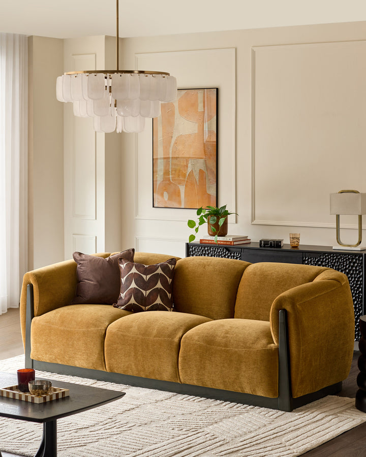 Teagan 3-seater sofa in ochre fabric with black wooden base and curved armrests, styled in a modern living room.