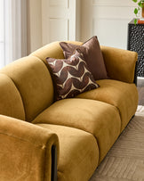 Teagan 3-seater sofa in ochre fabric with rolled arms, styled with patterned brown cushions in a modern living room setting.