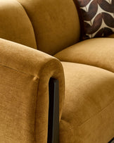 Teagan 3-seater sofa in ochre fabric, showing curved armrest detail with black wooden leg.