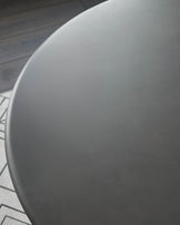 Close-up of round white dining table top surface with smooth finish and curved edge detail.