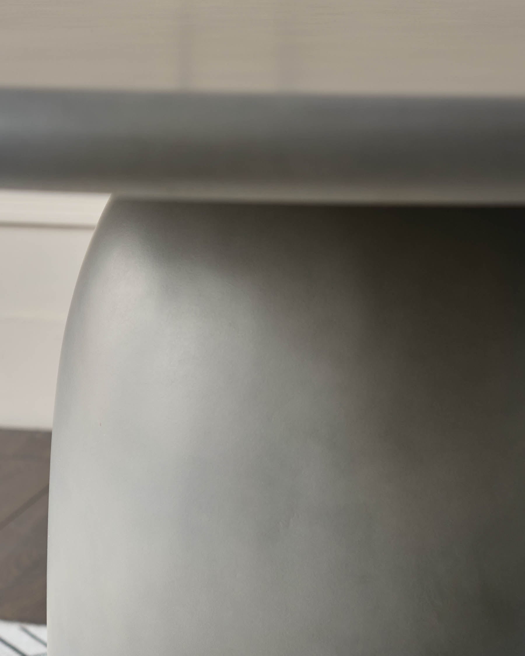 Close-up of white curved edge detail on dark grey garden dining table