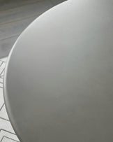 White round dining table top, close-up view showing smooth matte finish and curved edge detail.