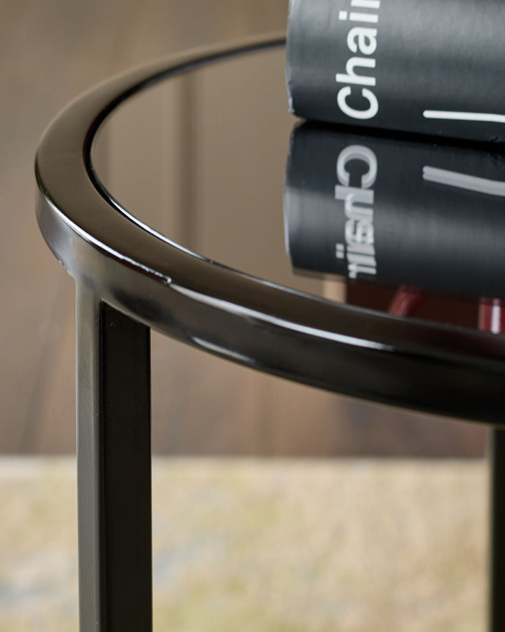 Smoked mirror tray table with black frame, curved edges, shown from a close-up side angle.